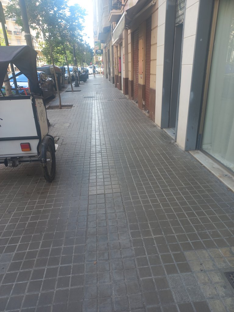 Itinerario de aproximación con banda pegada a fachada y con anchura accesible libre de obstáculos.