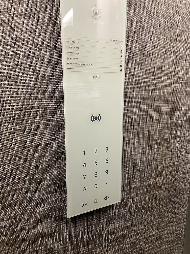 Ascensor con botones luminosos y panel informativo por plantas.