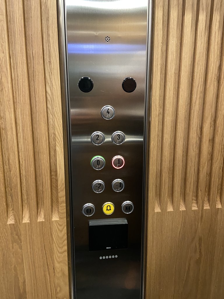 Ascensor accesible, botones en braille y con altura adecuada.