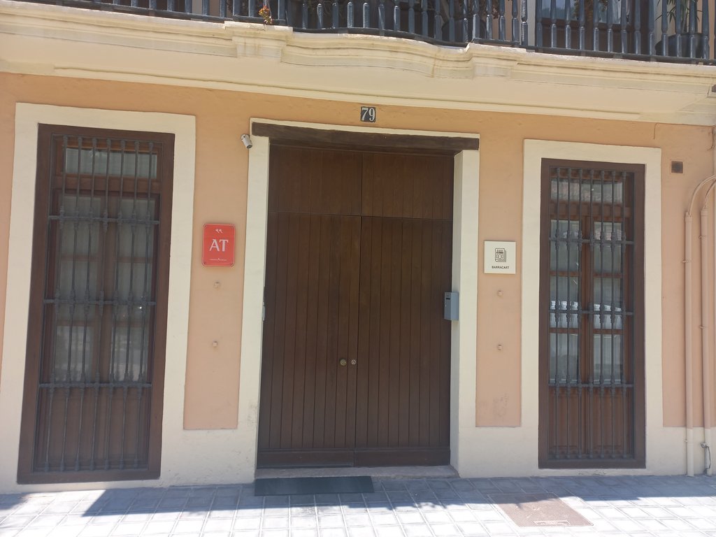 Fachada con número de propiedad y placas identificativas.