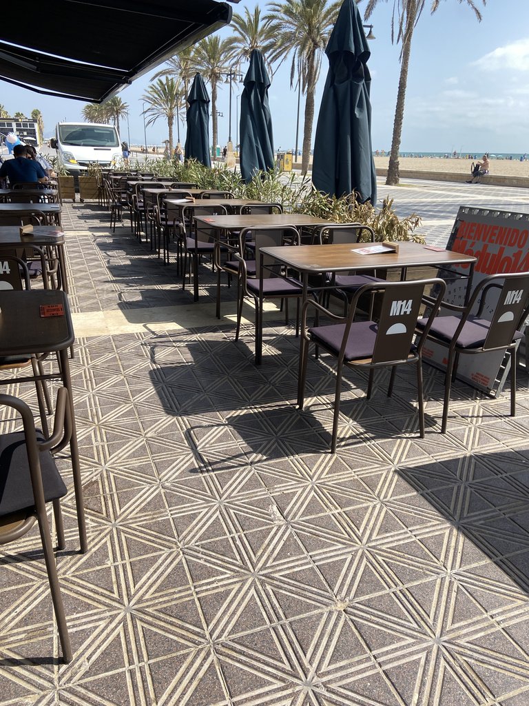 Terraza exterior accesible con espacio entre mesas.