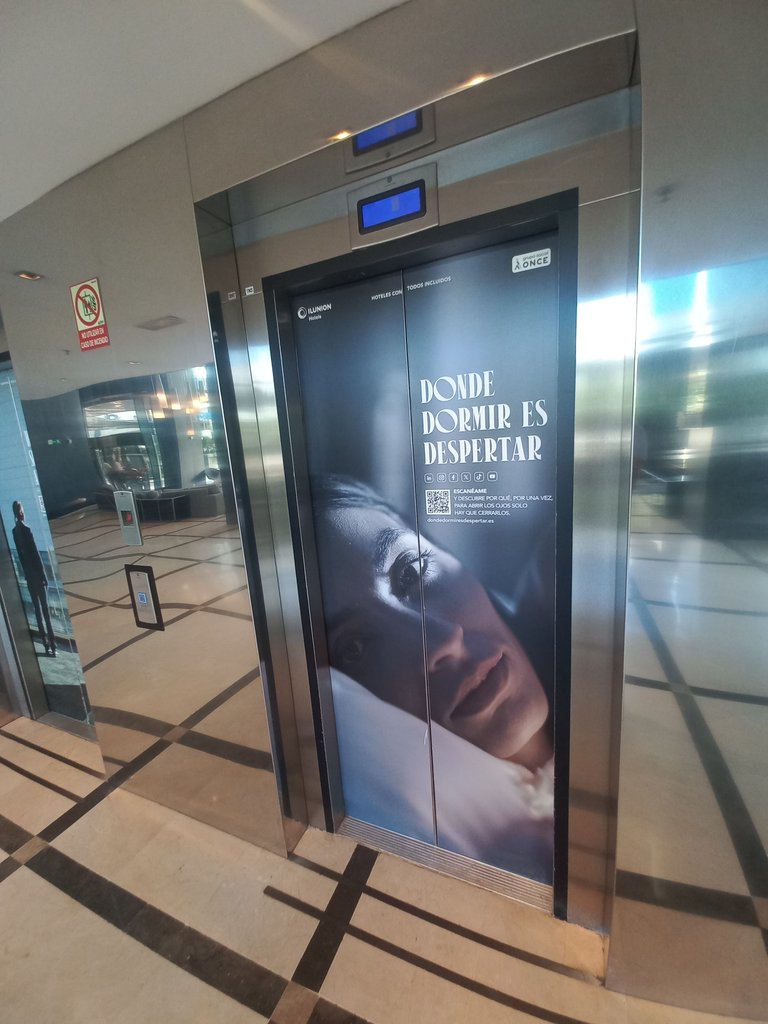 Módulo de ascensores con bandas de relieve en suelo y equipamiento accesible.