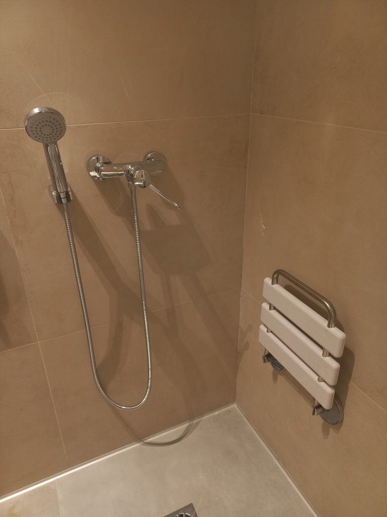Ducha con silla abatible.