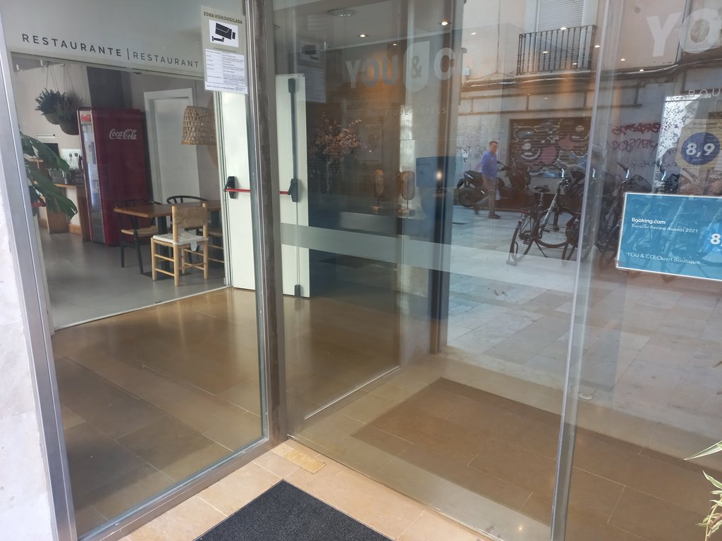 Acceso a través de puertas automáticas con bandas de contraste e identificación de vidrios.