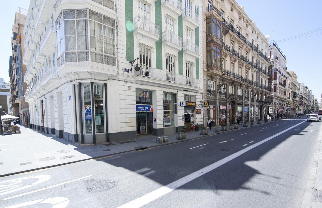 Fachada exterior con acera amplia y puerta automática. FVV