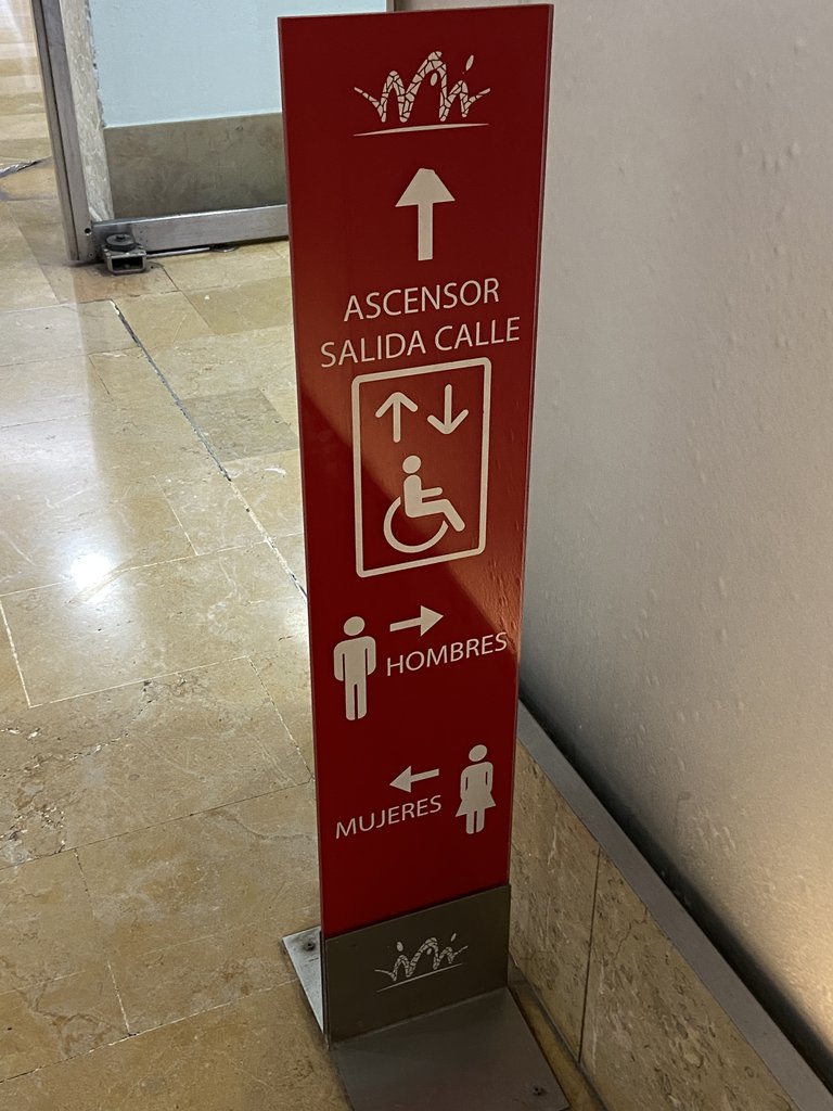 Señalización ascensor y baños comunes, en el interior del mercado.