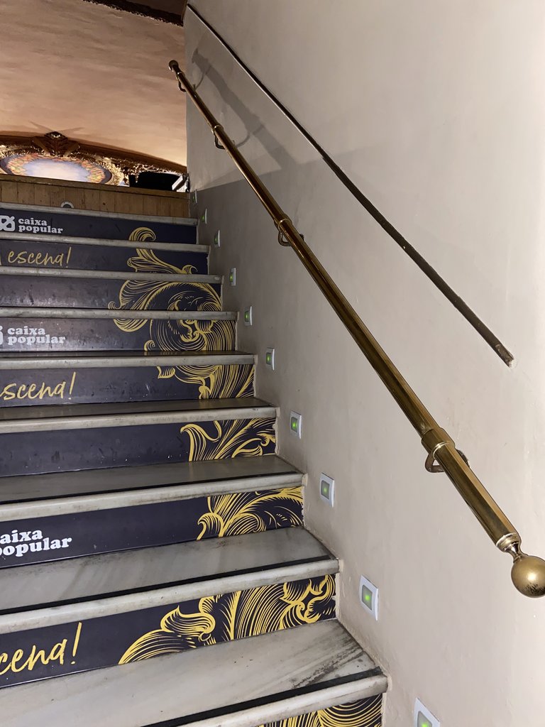 Acceso por escaleras, al graderío superior, con barandillas y escalones iluminados.