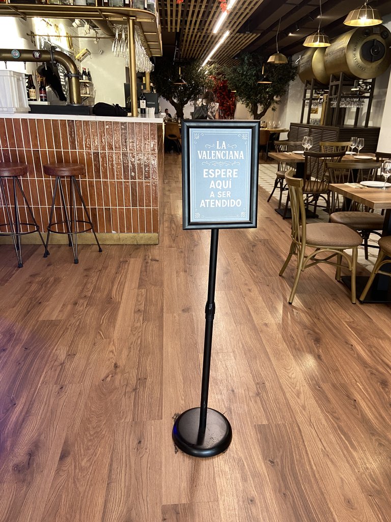 Senyalització, al costat de la porta, d'espera per a l'atenció al client.