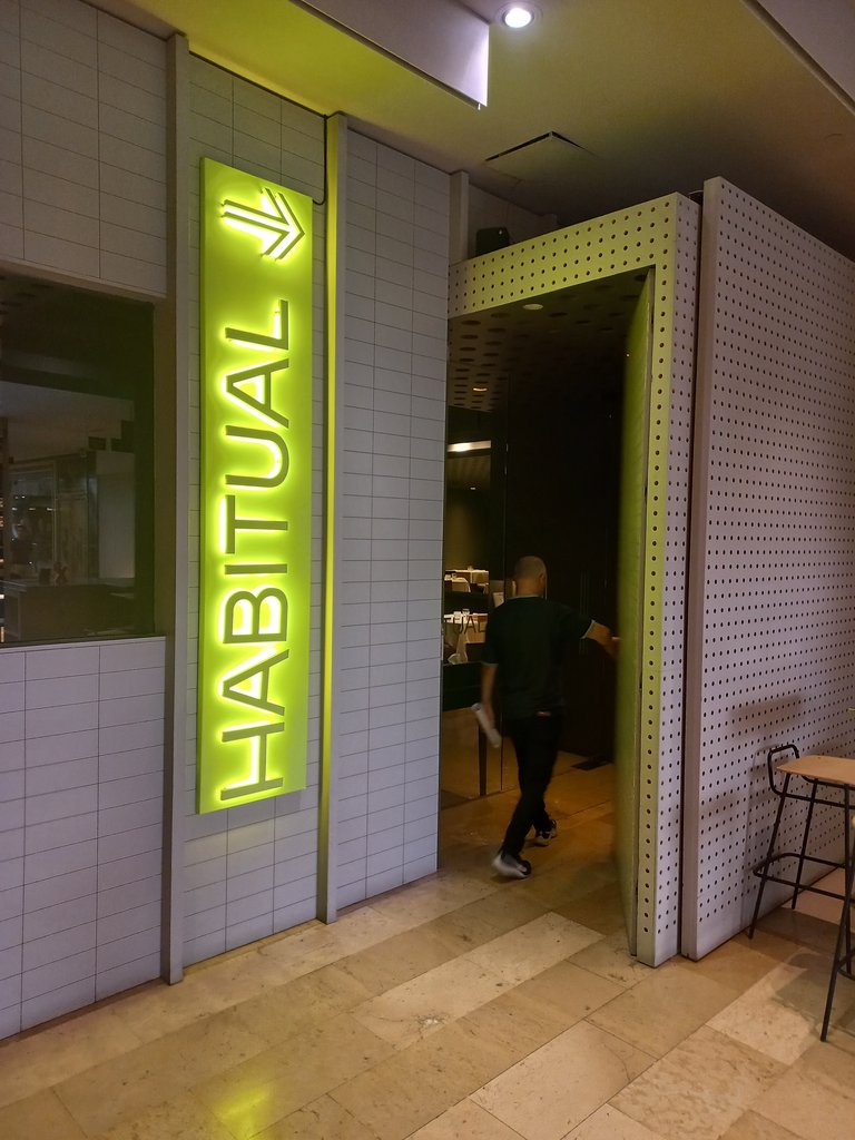 Establecimiento identificado desde el exterior con rótulo e indicador direccional.