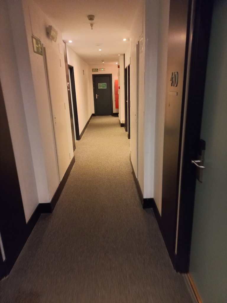 Il·luminació homogènia i color contrastat entre terra, parets i portes.