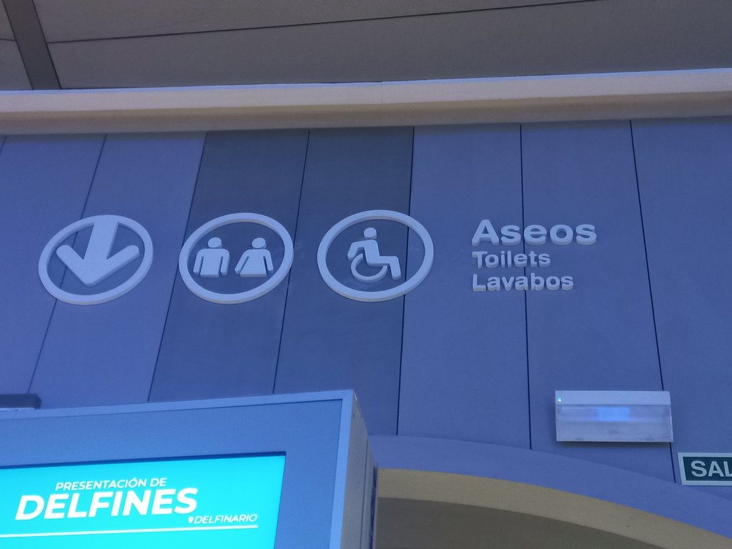 Señalética mediante indicador direccional, pictograma y texto.