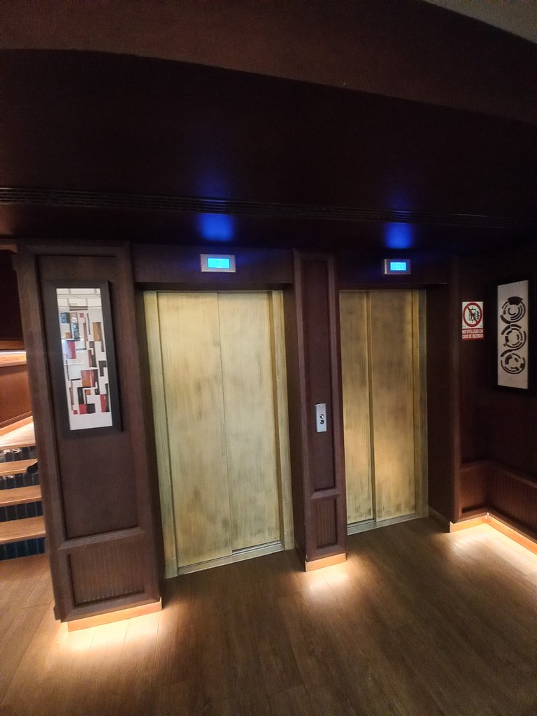 Ascensores accesibles con módulos identificados a través de contraste respecto al resto de pared.