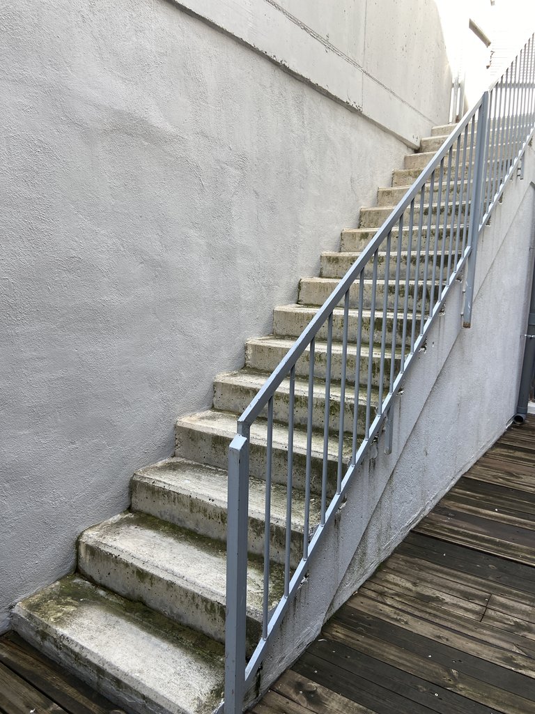 Escales per accedir a un altre espai d'activitat, amb barana de suport.