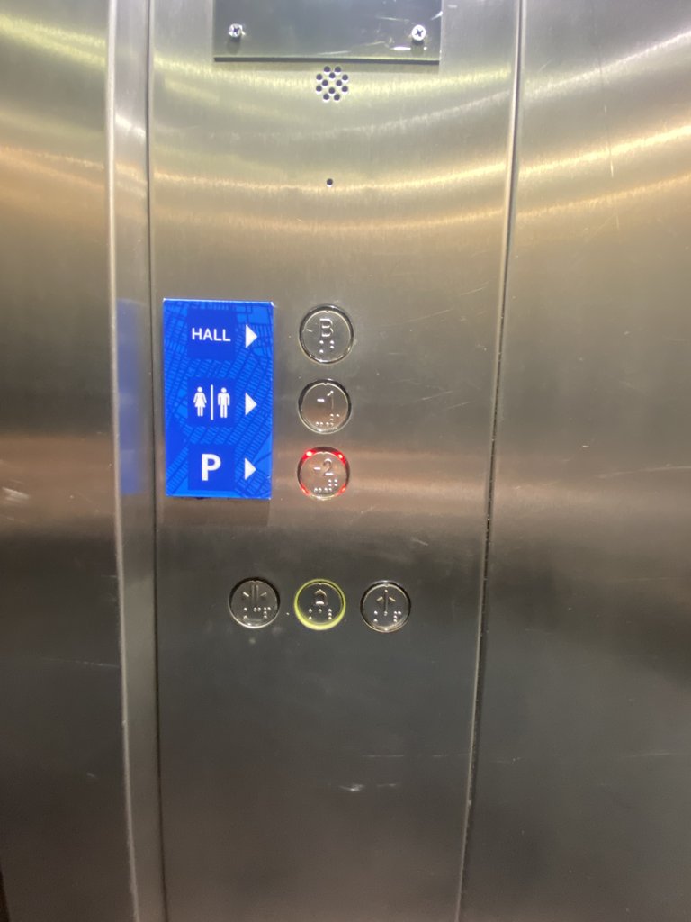 Accessible elevator with braille buttons, equipped with visual alert systems and buttons at the appropriate height.