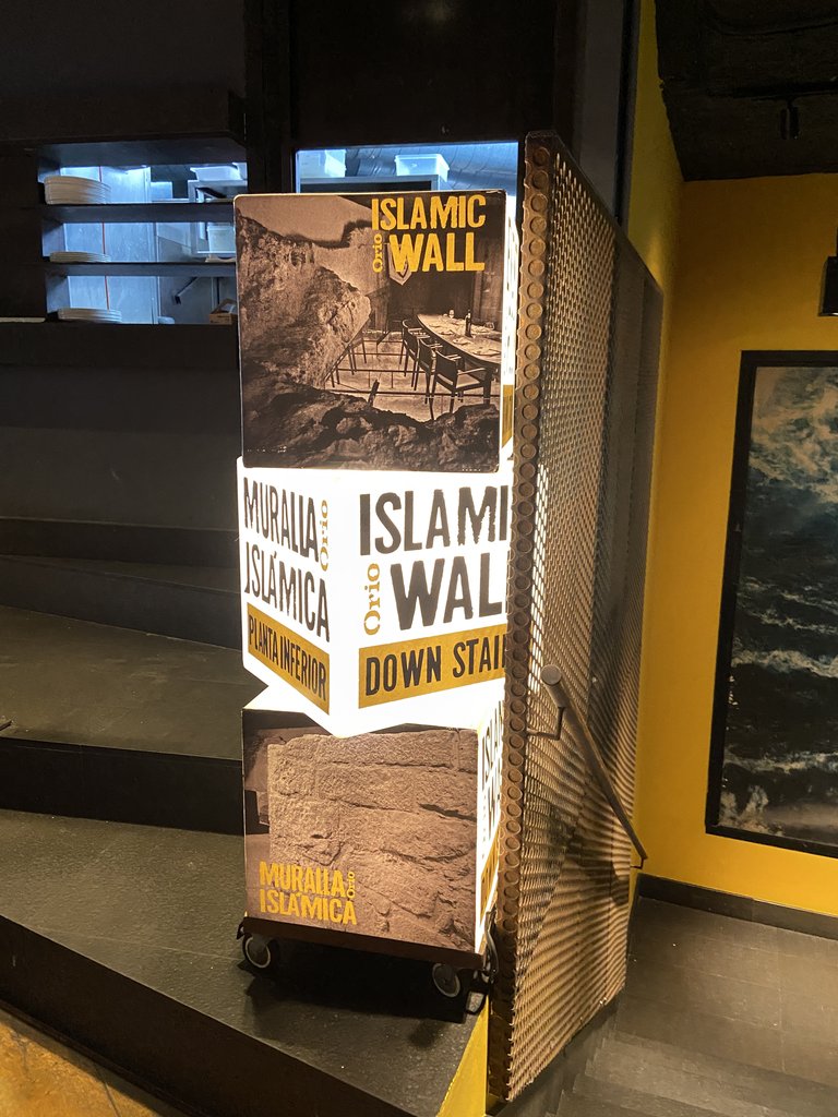 Señalización acceso muralla islámica en el interior del restaurante.