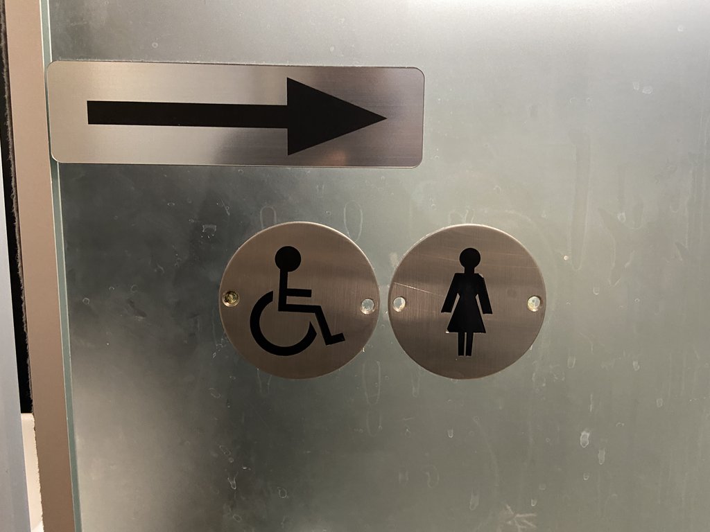 Señalización dirección baños adaptados comunes.