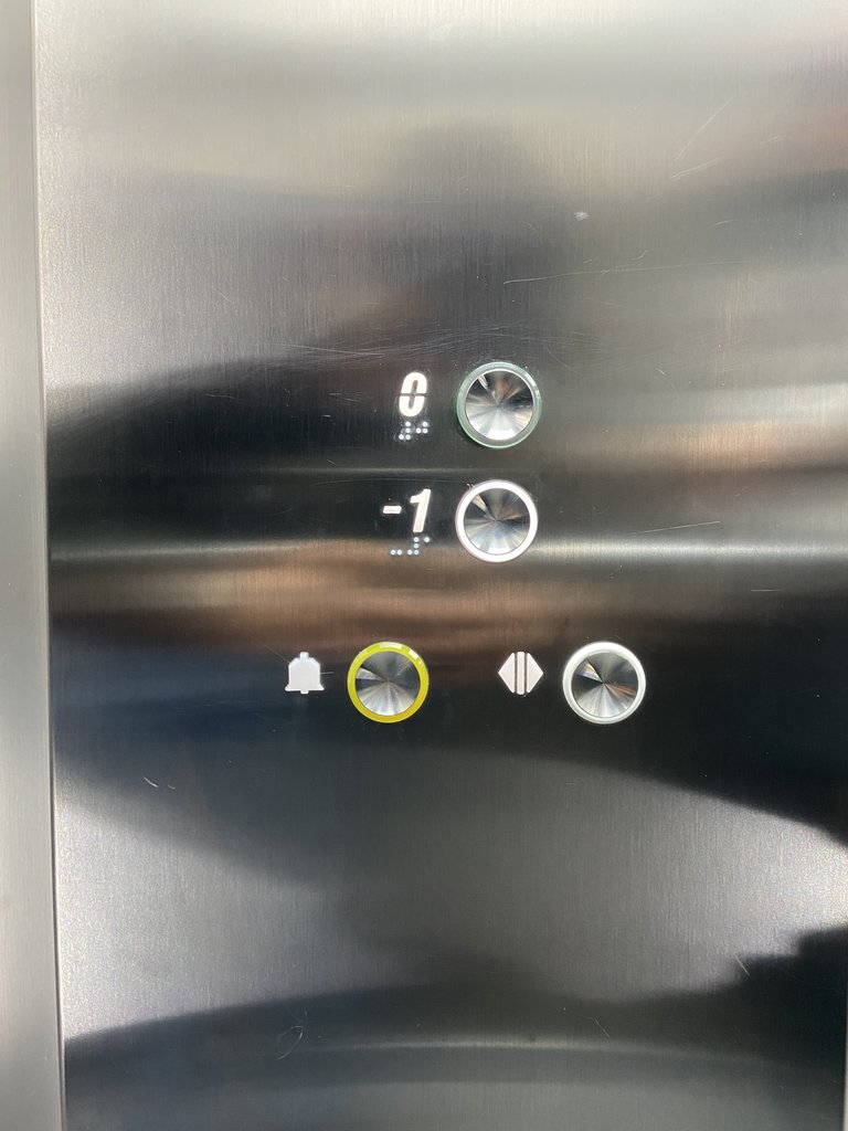 Accessible elevator with braille and illuminated buttons, panel at suitable height.