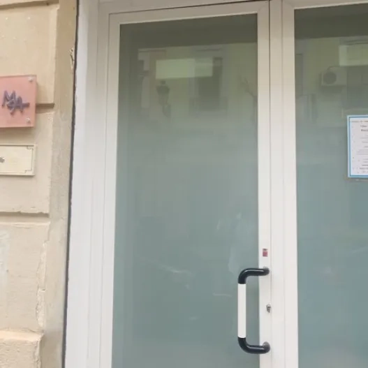 Puerta principal ancha, identificación clara en la fachada.