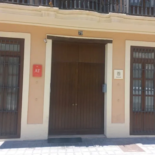 Fachada con número de propiedad y placas identificativas.