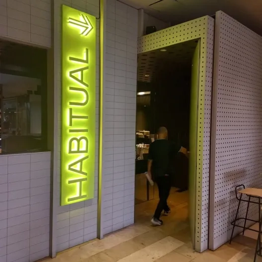 Establishment identified from the outside with a sign and directional indicator.