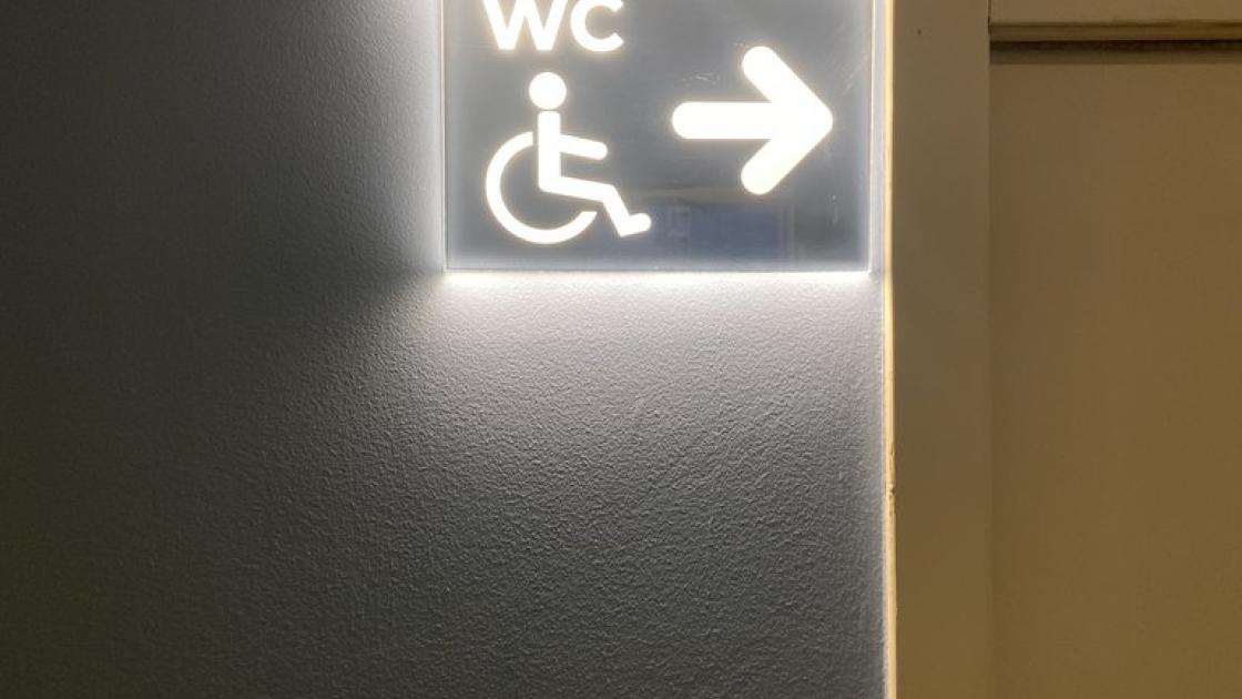 Señalización iluminable en baño adaptado común.