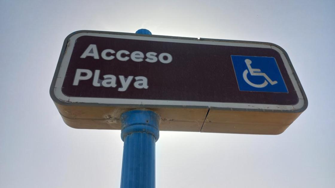 Señal vertical con texto y pictograma para identificar el acceso.