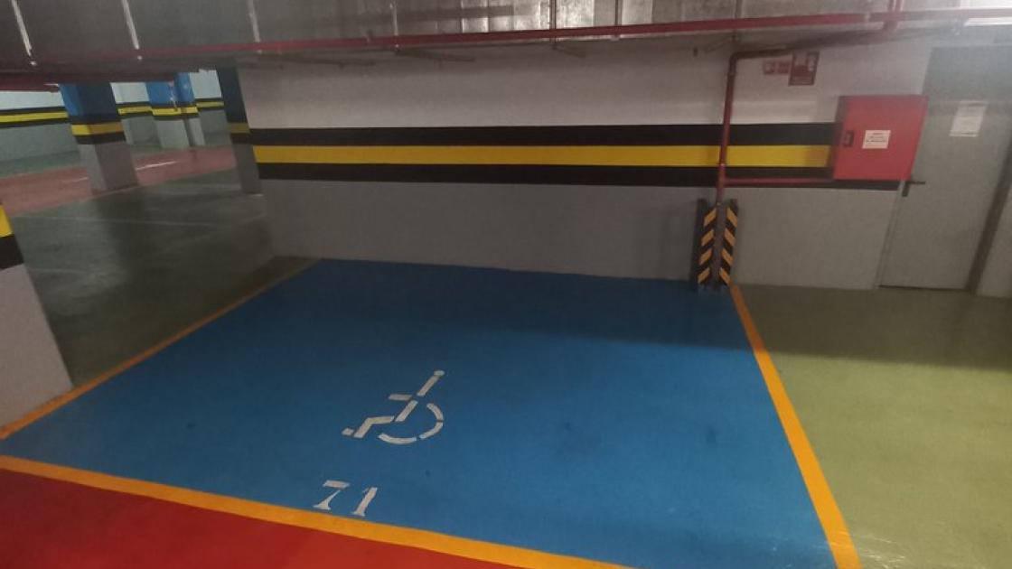 Zona de aparcamiento reservada para PMR en parking privado.