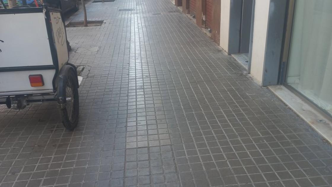 Itinerario de aproximación con banda pegada a fachada y con anchura accesible libre de obstáculos.