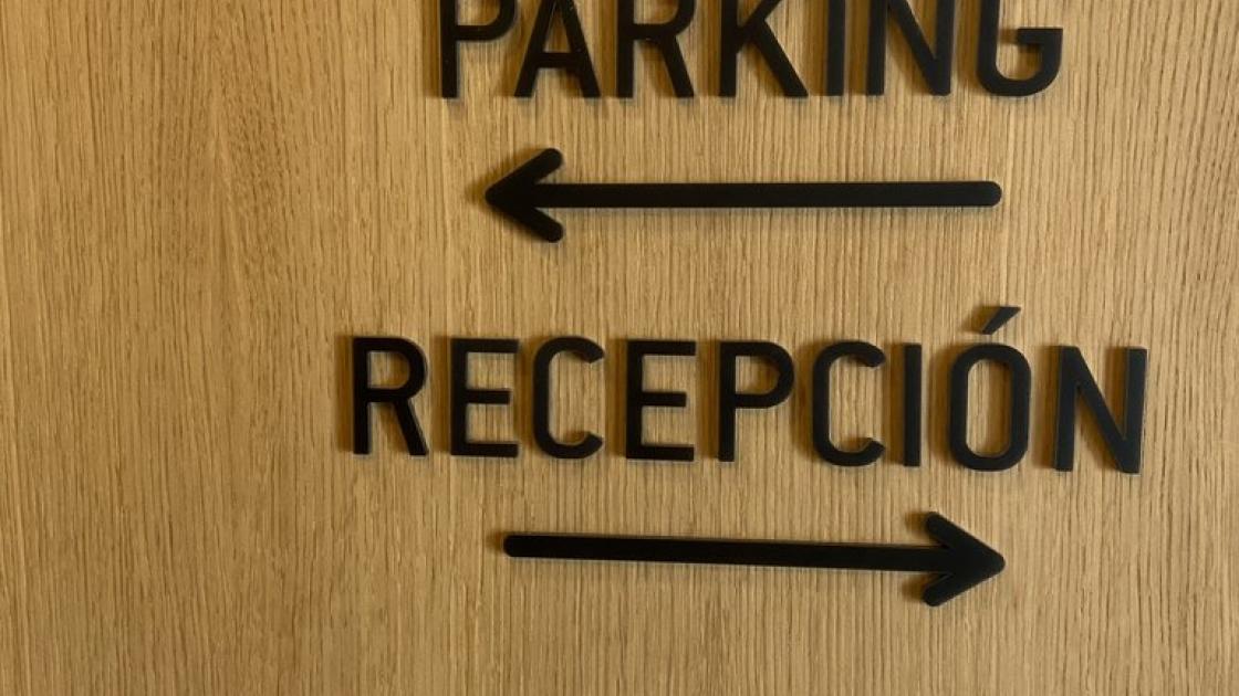 Señalización dirección parking y recepción.