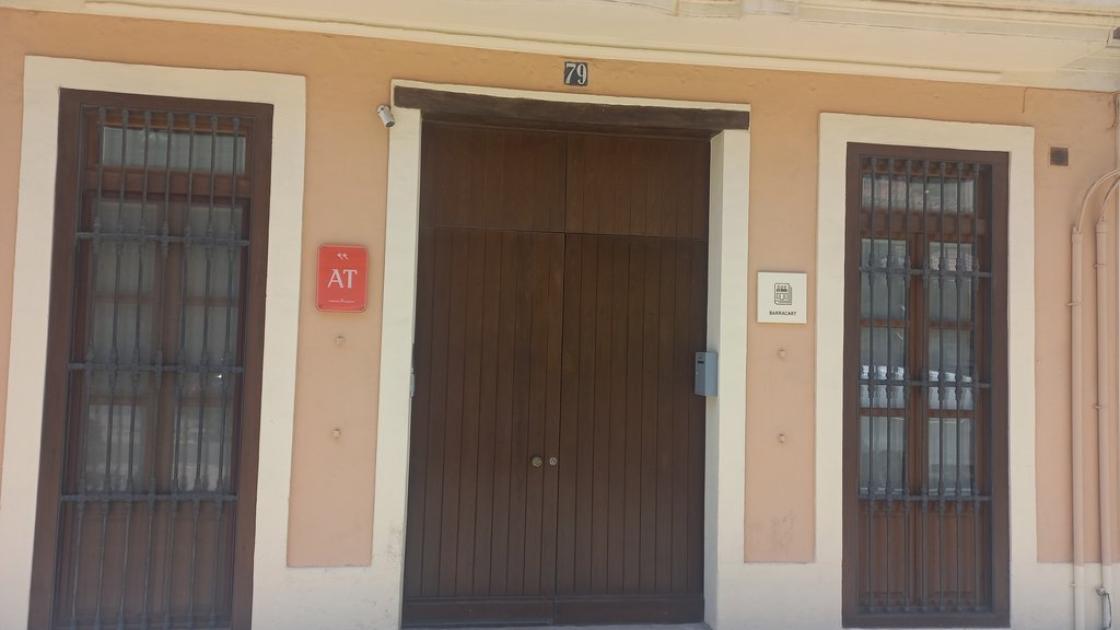 Façana amb número de propietat i plaques identificatives.