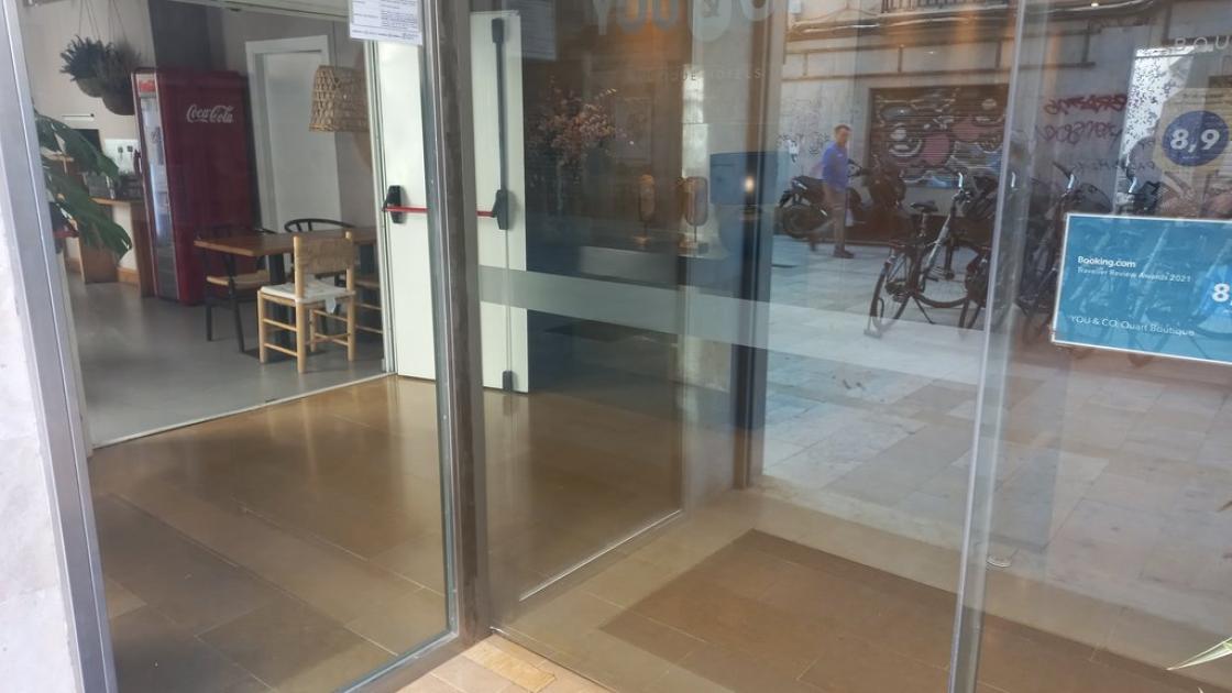 Access through automatic doors with contrast bands and glass identification.