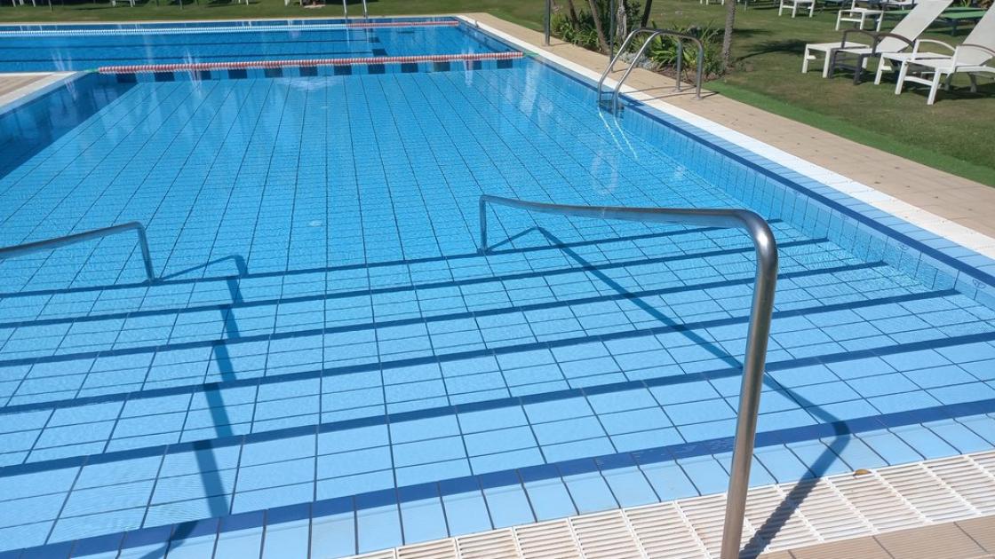 Acceso a piscina mediante escaleras con pasamanos.