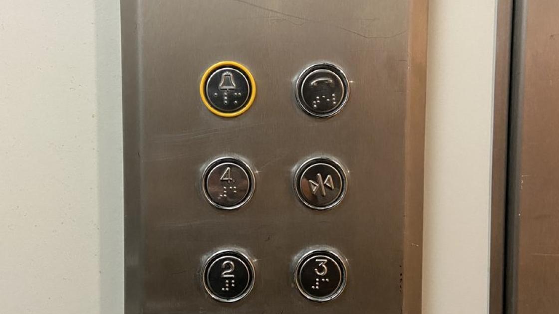 Elevator equipped with braille buttons and set at appropriate height.