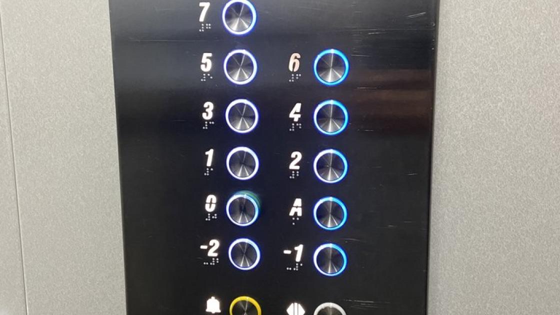 Elevator equipped with braille and illuminated buttons, control panel at appropriate height, and visual alert systems.