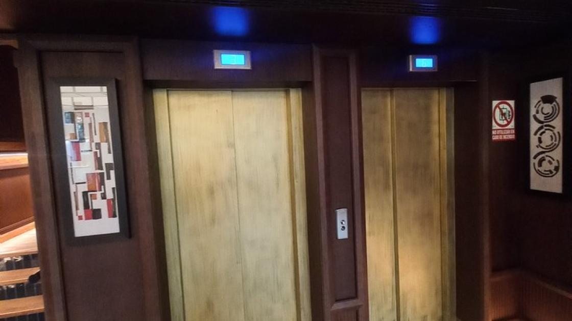 Ascensores accesibles con módulos identificados a través de contraste respecto al resto de pared.