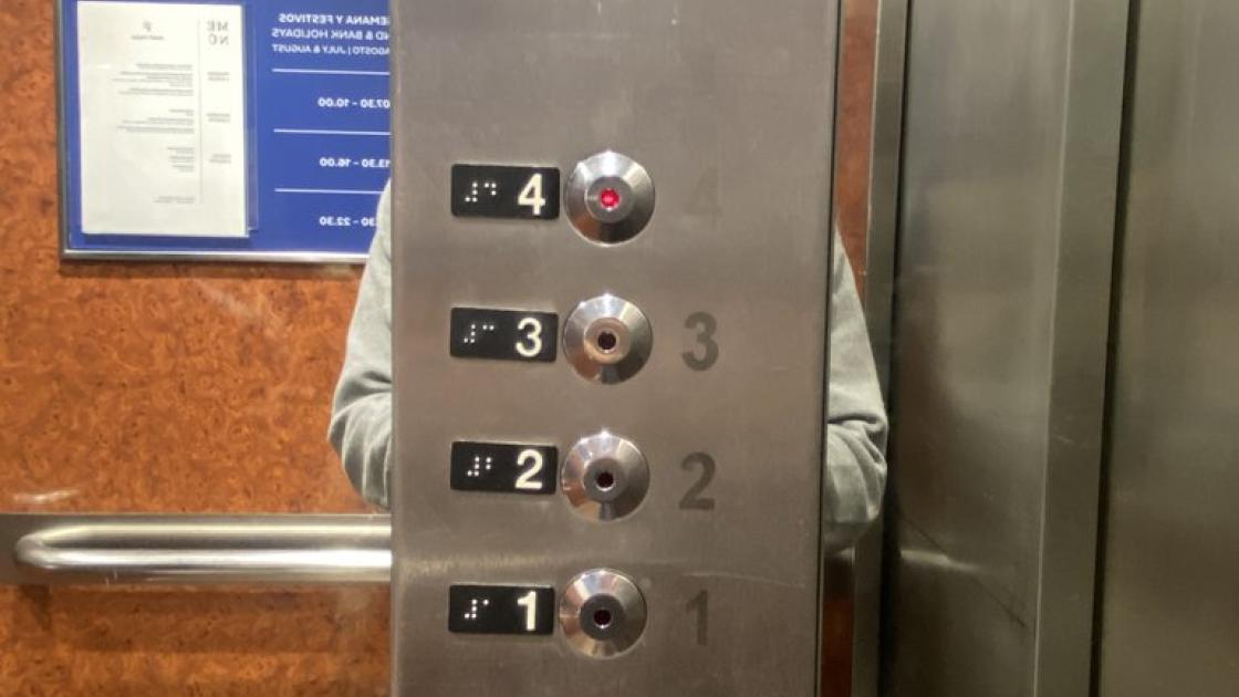 Accessible elevator with braille buttons, equipped with visual alert systems and buttons at the appropriate height.
