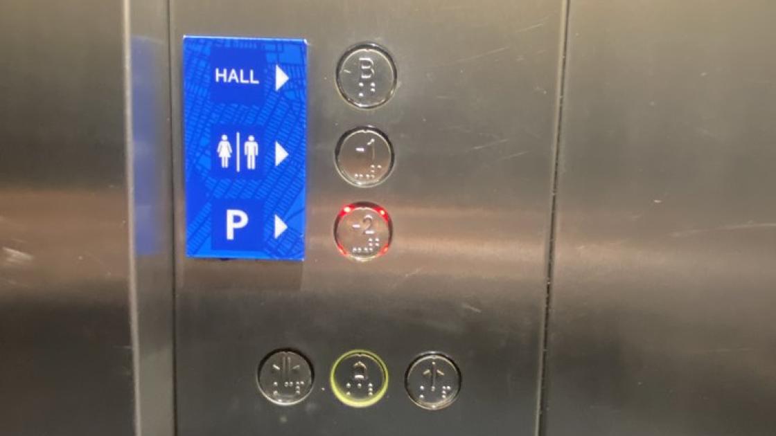 Accessible elevator with braille buttons, equipped with visual alert systems and buttons at the appropriate height.