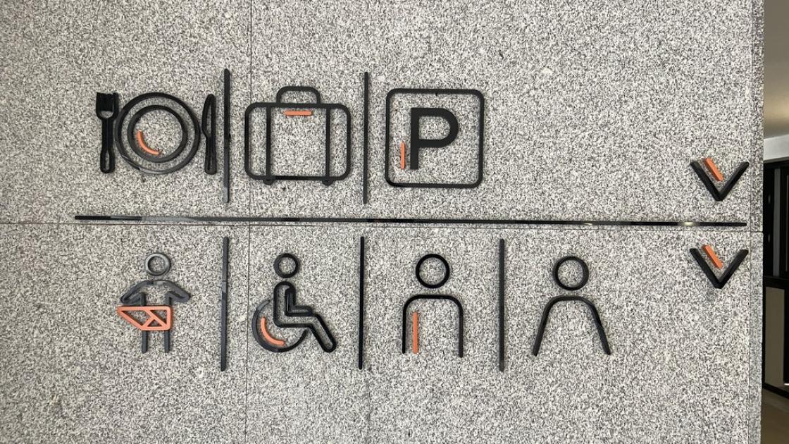 Pictogrames en alt relleu indicant la direcció espais.
