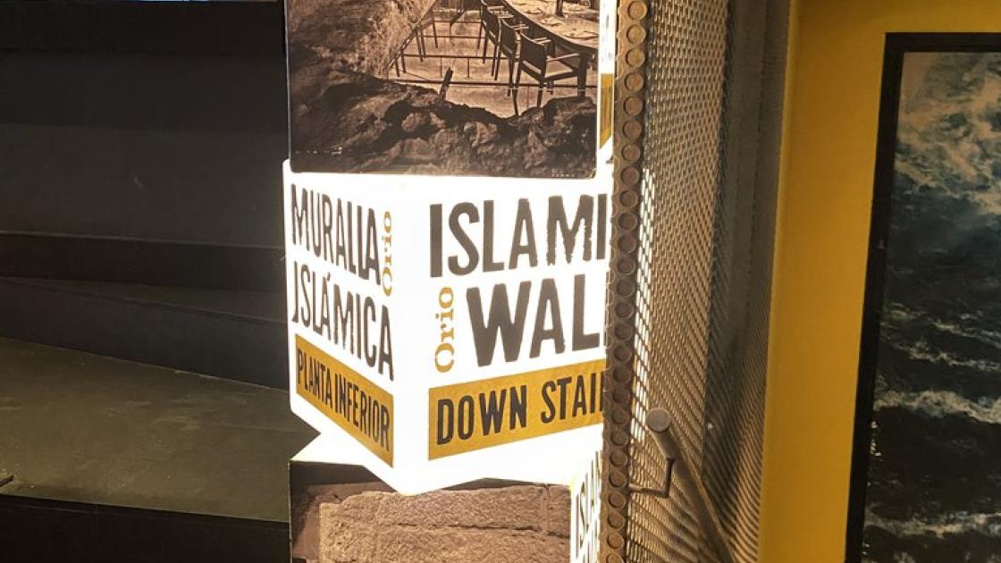 Señalización acceso muralla islámica en el interior del restaurante.