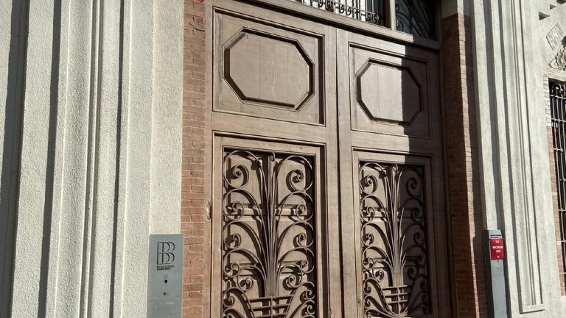 Acceso principal al establecimiento llano con puertas abiertas durante el horario de apertura.