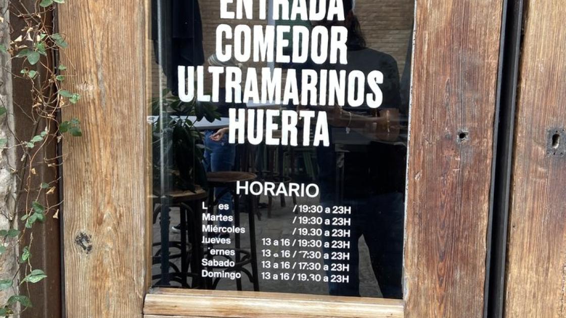 Signage for dining room entrance and opening hours.
