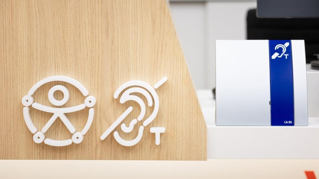 Signage for services adapted for people with disabilities, and magnetic loop at the customer service desk.