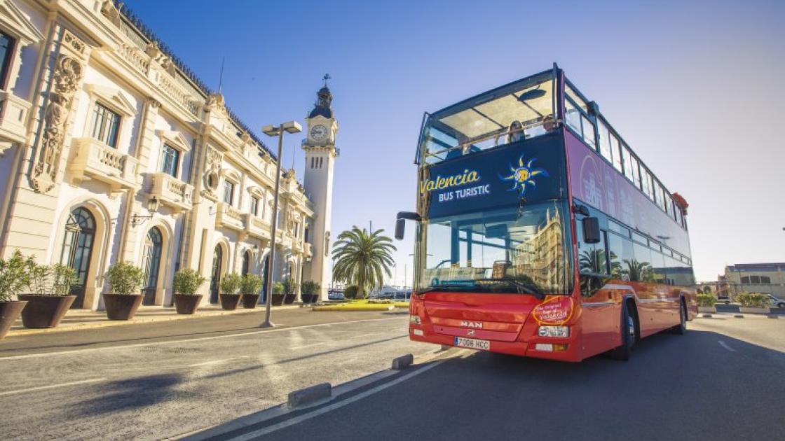 edificio del reloj y bus turistic rojo