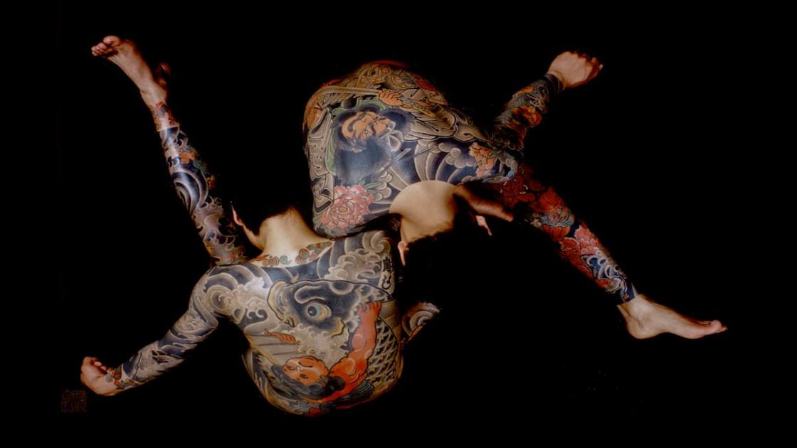 Dos hombres tatuados entrelazados
