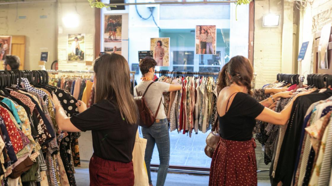 personas mirando ropa en mercadillo