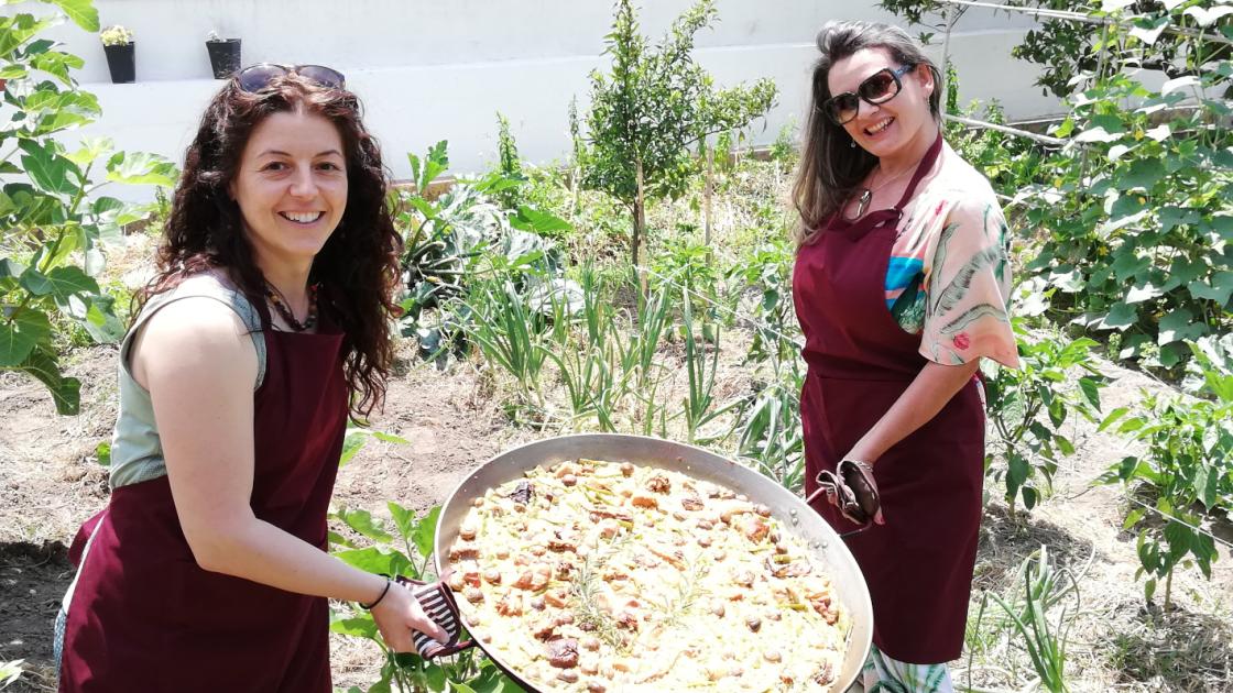Turistas mostrando una paella cocinada en el taller de paella