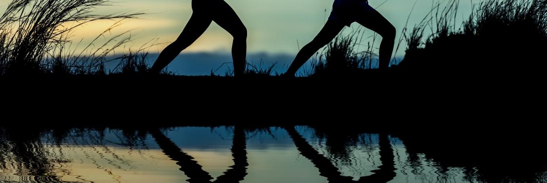 dos deportistas practicando yoga al aire libre