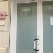 Puerta principal ancha, identificación clara en la fachada.