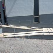 Desnivel resuelto mediante rampa practicable (pendiente, meseta, pasamanos y barandilla).