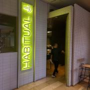 Establecimiento identificado desde el exterior con rótulo e indicador direccional.